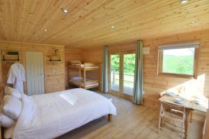 Dormitorio con cama y escritorio en una cabaña de madera en Anniston Mill Cabin 2, en Arbroath