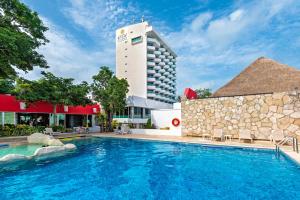 a hotel with a swimming pool in front of a building at El Cid La Ceiba Beach in Cozumel
