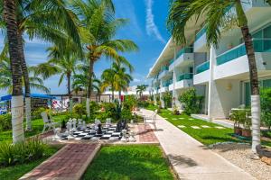 a chess board in front of a building with palm trees at El Cid La Ceiba Beach in Cozumel