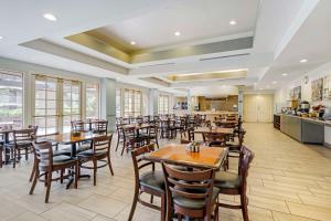 Best Western Plus Palm Desert Resort في بالم ديزرت: مطعم بطاولات وكراسي ومطبخ