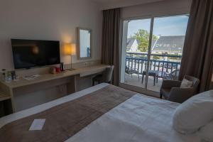 ヴァンヌにあるBest Western Plus Le Roof Vannes Bord de Merのベッド1台付きのホテルルームで、バルコニーが付いています。