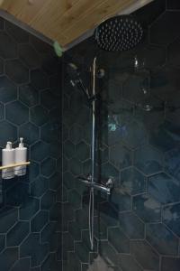 y baño con ducha de azulejos azules. en Anniston Mill Cabin 2, en Arbroath