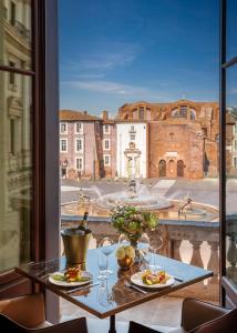 羅馬的住宿－Anantara Palazzo Naiadi Rome Hotel - A Leading Hotel of the World，一张带食物盘的桌子,享有建筑的景色