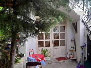 ein weißes Haus mit einem Tisch vor einer Tür in der Unterkunft Stay with Adem in Skopje