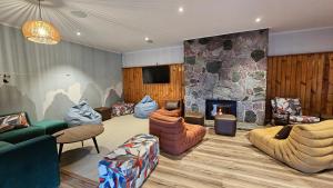 una sala de estar con sofás y una chimenea de piedra. en Haka House Wanaka en Wanaka