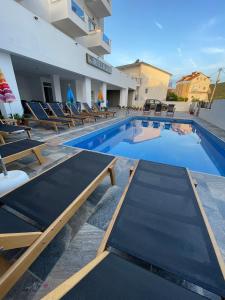basen z krzesłami i hotel w obiekcie Hotel SEADEL w mieście Ksamil