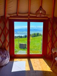 a room with a window with a view of a field at Woda Góry Las - glamping CAŁOROCZNY in Szlembark