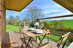 een houten tafel op een terras met wijnglazen bij Anniston Mill Cabin 1 in Arbroath