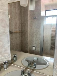 ein Bad mit einem Waschbecken und einem Spiegel in der Unterkunft Departamento 4 habitaciones 12 personas vista al mar 8vo piso Playa Almendro in Tonsupa
