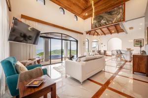 a living room with a white couch and a tv at Casa Vista de Paraiso in Nuevo Colón