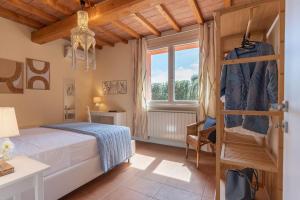 a bedroom with a bed and a window at Casa Melatina ToscanaOneHH in Riparbella