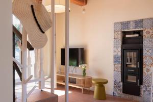 a living room with a television and a staircase at Casa Melatina ToscanaOneHH in Riparbella