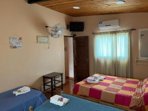 a bedroom with two beds and a fan at Descanso el abuelo in Londres
