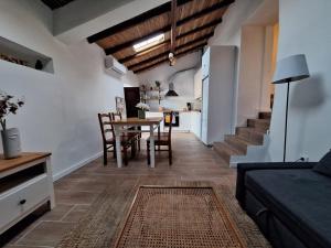 Una sala de estar con mesa y sillas y una cocina. en Typical house in Algarve 5m from beach, en Porches