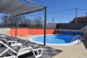 een zwembad met ligstoelen en een parasol bij Apartment in Risika - Insel Krk 50492 in Risika