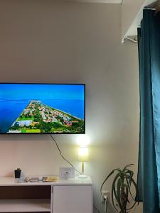 TV de pantalla plana colgada en la pared en Hermoso apartamento en puerta de la Ciudad Vieja, en Montevideo