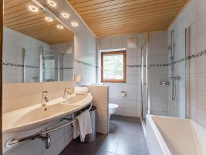 Un baño con lavabo, bañera y ducha. en Saalach, en Saalbach Hinterglemm 27 fotos más
