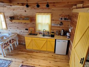 a kitchen with yellow cabinets and a table in a cabin at Badece Farm Yellow House in Bergama +29 photos