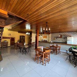 restauracja z drewnianymi sufitami, stołami i krzesłami w obiekcie Pousada das Flores w mieście Conservatória