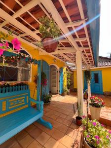 patio z niebieską ławką i kwiatami w obiekcie Pousada das Flores w mieście Conservatória