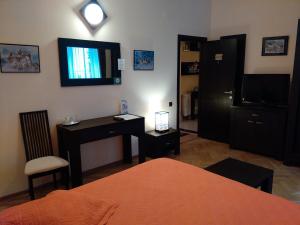 a bedroom with a desk and a television on the wall at Casa Vacanza Brasov in Braşov