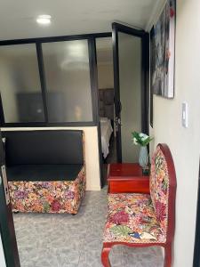 Zimmer mit einem Sofa, einem Stuhl und einem Tisch in der Unterkunft Ecohotel Java in Manizales