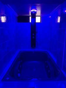 ein blaues Zimmer mit einer Badewanne mit Licht in der Unterkunft Ecohotel Java in Manizales