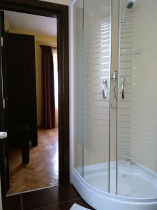 a bathroom with a tub with a glass shower at Rami House central double rooms in Braşov