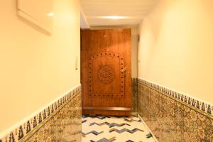 a hallway with a wooden door and a tile floor at Luxurious Riad Center Rabat Dar Al Jeld in Rabat