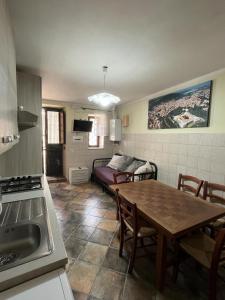 a kitchen and dining room with a table and a couch at da sciuri case vacanza Barisciano in Barisciano
