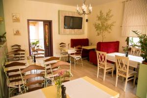 ein Restaurant mit Tischen und Stühlen sowie einem TV in der Unterkunft Seasons SPA Boutique Hotel in Kozin