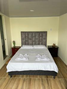 a bedroom with a bed with two white towels on it at Ecohotel Java in Manizales