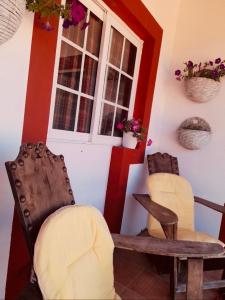 um quarto com duas cadeiras, uma mesa e uma janela em Quinta da Maínha - Charming Houses em Braga