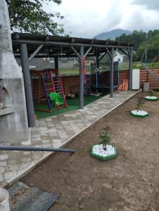 a playground with a play area with two trees in it at У Ондраша in Yasinya