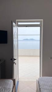 a bedroom with a sliding glass door with a view of the ocean at Vila Endry in Vlorë
