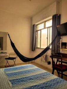 a bed with a hammock in a bedroom at Jóia no Bairro de Fátima - Lapa in Rio de Janeiro +13 photos