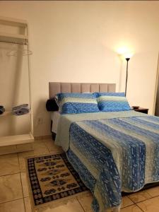 a bedroom with a bed with a blue comforter at Jóia no Bairro de Fátima - Lapa in Rio de Janeiro