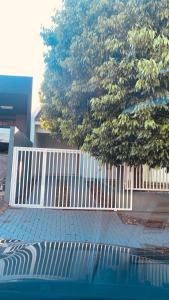 帕圖布蘭科的住宿－Casa grande em bairro tranquilo，树和游泳池旁的白色围栏