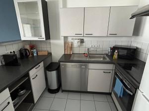 a small kitchen with a sink and a microwave at RANGE Loft-Apartment Balkon Netflix 5 Personen in Fellbach