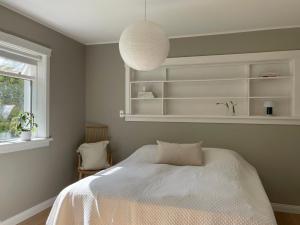 a bedroom with a bed and a pendant light at Comfortable and stylish apartment in quiet area downtown in Reykjavík