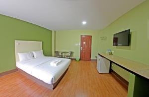 a hotel room with a bed and a flat screen tv at Central Park Hotel in Sing Buri