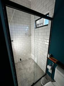un bagno con doccia in vetro e WC di Casa Lamparina a Santa Fé do Sul