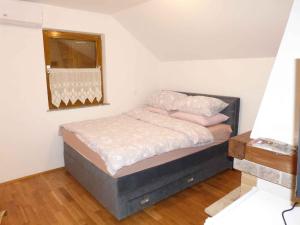 a bedroom with a bed with pink pillows and a mirror at Holiday home in Dragatus - Kranjska (Krain) 50798 in Dragatuš