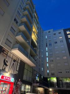a tall building in a city at night at DG Apartment Prishtina in Pristina