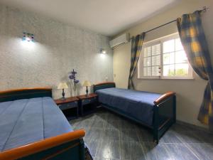 a bedroom with two beds and a window at Alcaria Pool House in Altura +8 photos