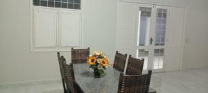 a table with chairs and a vase of flowers on it at Casa flor de Mandacaru in Piranhas +16 photos