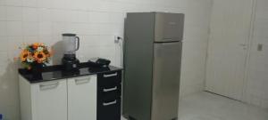 a kitchen with a refrigerator and a counter with a blender at Casa flor de Mandacaru in Piranhas