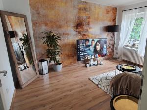uma sala de estar com televisão e piso em madeira em Dream Home in Dortmund em Dortmund