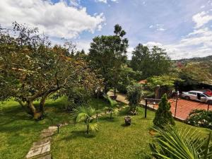 Una vista de un jardín con árboles y un coche. en Chalé de montaña con Jacuzzi, en Guarne