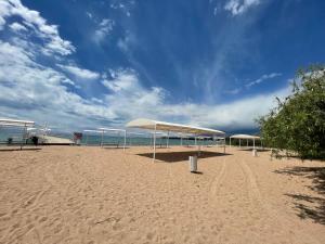 a sandy beach with umbrellas on top of it at Talisman Village House in Bosteri